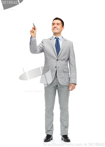 Image of happy businessman in suit writing something