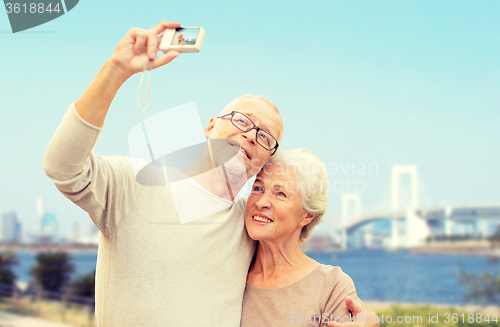 Image of senior couple with camera over rainbow bridge