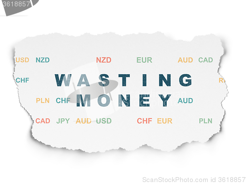 Image of Money concept: Wasting Money on Torn Paper background