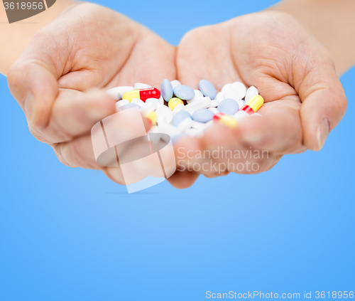 Image of close up of senior woman hands with pills