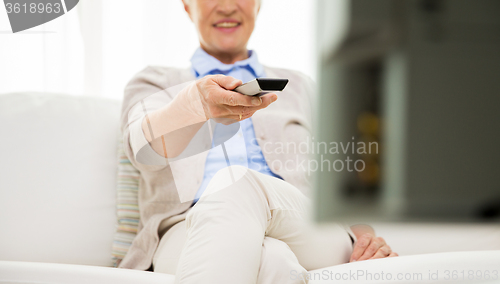 Image of close up of happy senior woman watching tv at home