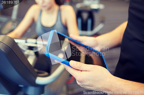 Image of close up of trainer hands with tablet pc in gym