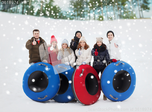 Image of group of smiling friends with snow tubes