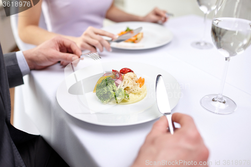 Image of close up of couple eating appetizers at restaurant