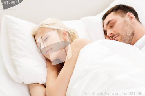 Image of happy couple sleeping in bed at home