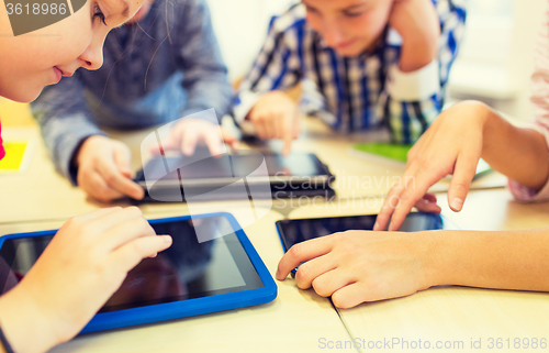 Image of close up of school kids playing with tablet pc 