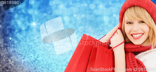 Image of woman in red hat and scarf with shopping bags