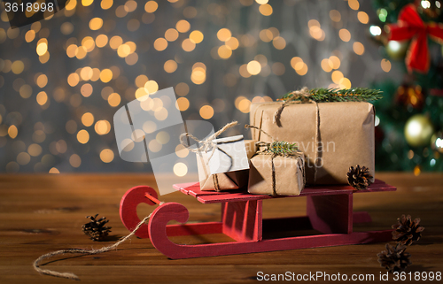 Image of close up of christmas gift boxes on wooden sleigh