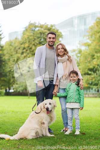 Image of happy family with labrador retriever dog in park