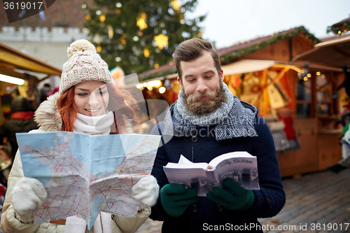 Image of happy couple with map and city guide in old town