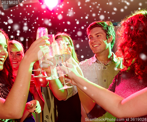 Image of smiling friends with glasses of champagne in club