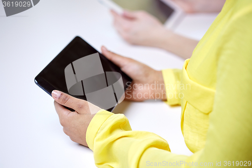 Image of close up of female hands with tablet pc at table