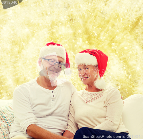 Image of happy senior couple in santa helper hats