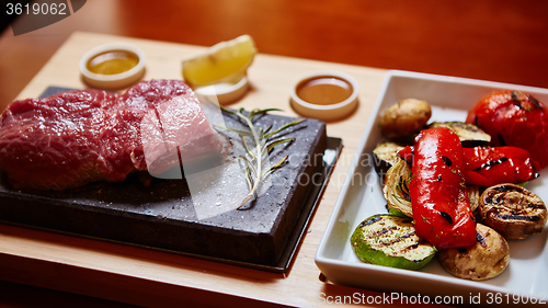 Image of meat grilled on astone with vegetables