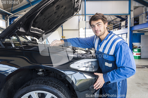 Image of Car mechanic under the hood