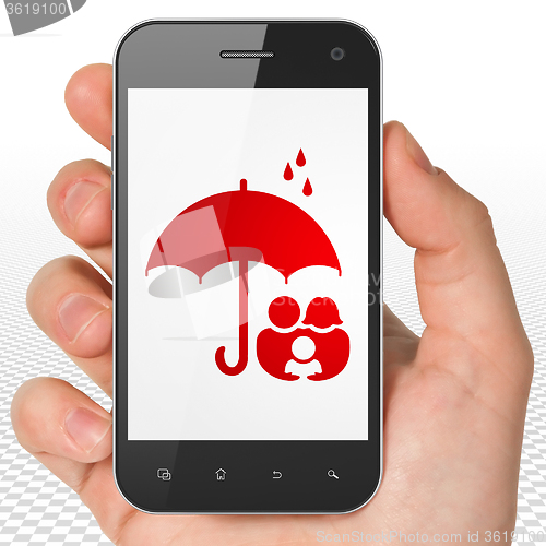 Image of Security concept: Hand Holding Smartphone with Family And Umbrella on display