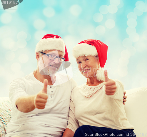 Image of happy senior couple in santa helper hats