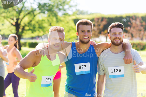 Image of happy friends with racing badge numbers