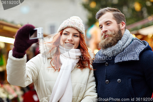 Image of couple taking selfie with smartphone in old town