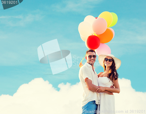 Image of smiling couple with air balloons outdoors