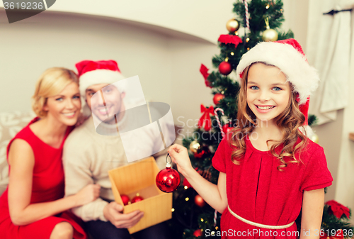 Image of smiling family decorating christmas tree