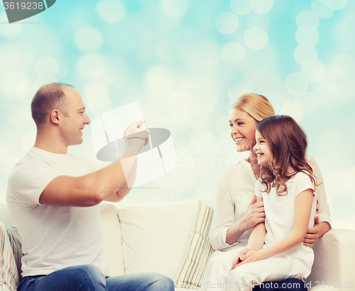 Image of happy family with camera at home