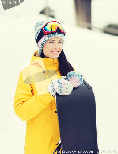 Image of happy young woman with snowboard outdoors
