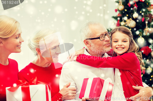 Image of smiling family with gifts at home