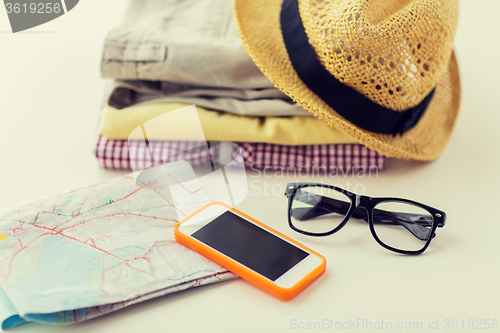 Image of close up of summer clothes and travel map on table