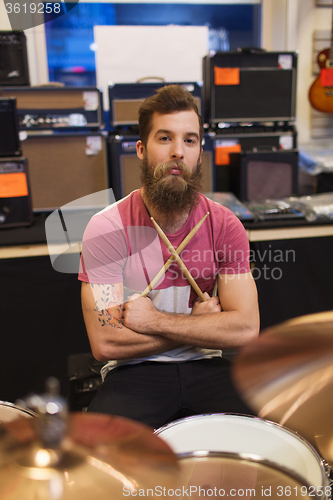 Image of male musician with cymbals at music store