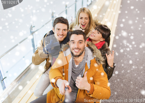 Image of happy friends taking selfie on skating rink