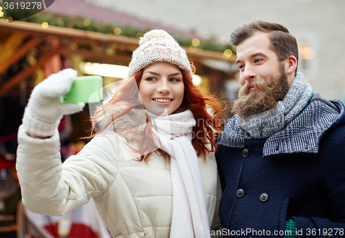Image of couple taking selfie with smartphone in old town