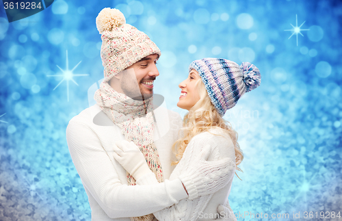 Image of happy couple in winter clothes hugging over lights