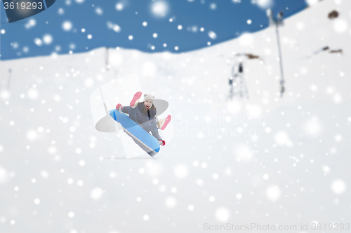 Image of happy teenage girl sliding down on snow tube