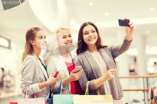 Image of women with smartphones shopping and taking selfie