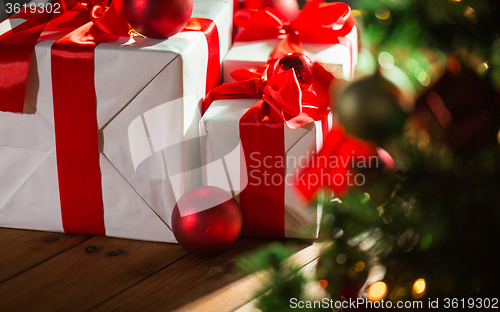 Image of gift boxes and red balls under christmas tree