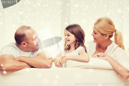 Image of smiling parents and little girl at home