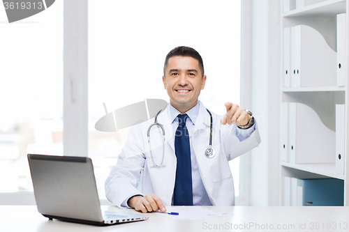 Image of smiling doctor pointing finger at you in office