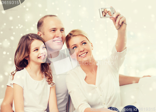 Image of happy family with camera taking picture at home