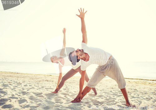 Image of couple making yoga exercises outdoors