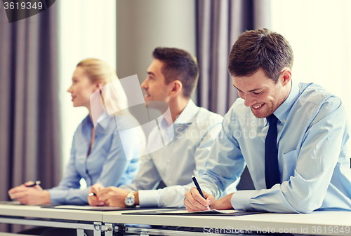 Image of group of smiling businesspeople meeting in office