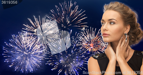 Image of beautiful woman wearing earrings over firework