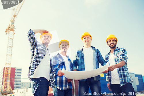 Image of group of builders with tablet pc and blueprint