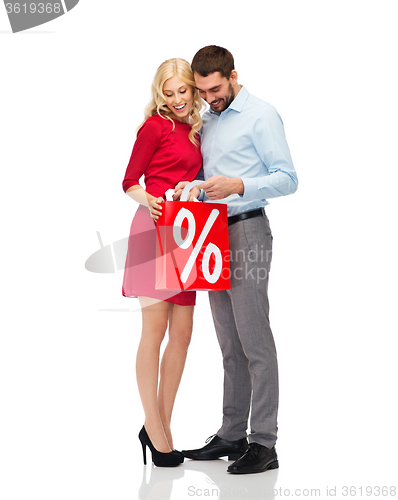 Image of happy couple looking into red shopping bag