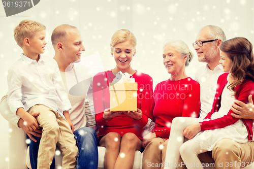 Image of smiling family with gifts at home