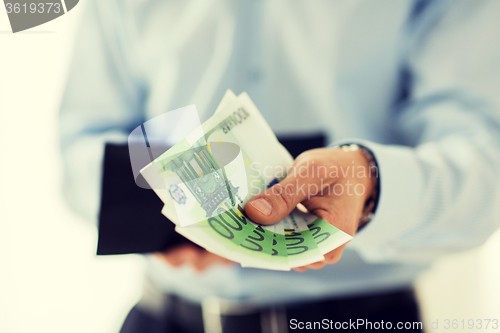 Image of close up of businessman hands holding money