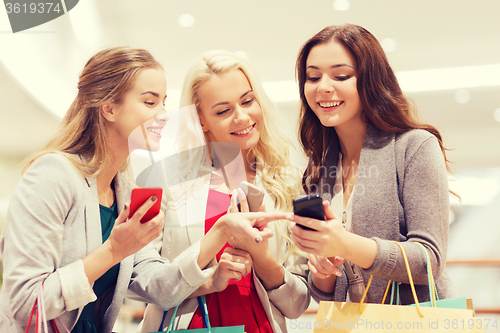 Image of happy women with smartphones and shopping bags