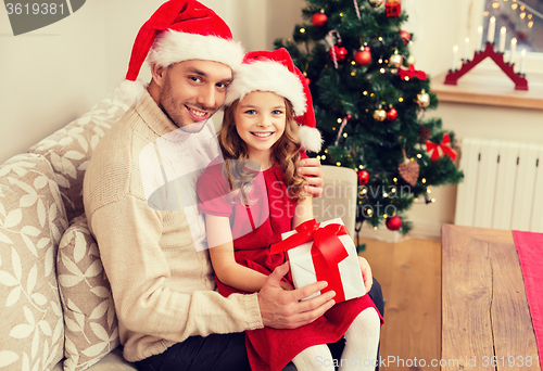 Image of smiling father and daughter holding gift box