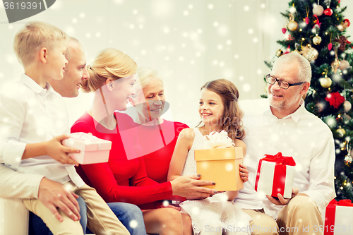 Image of smiling family with gifts at home