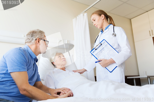 Image of senior woman and doctor with clipboard at hospital